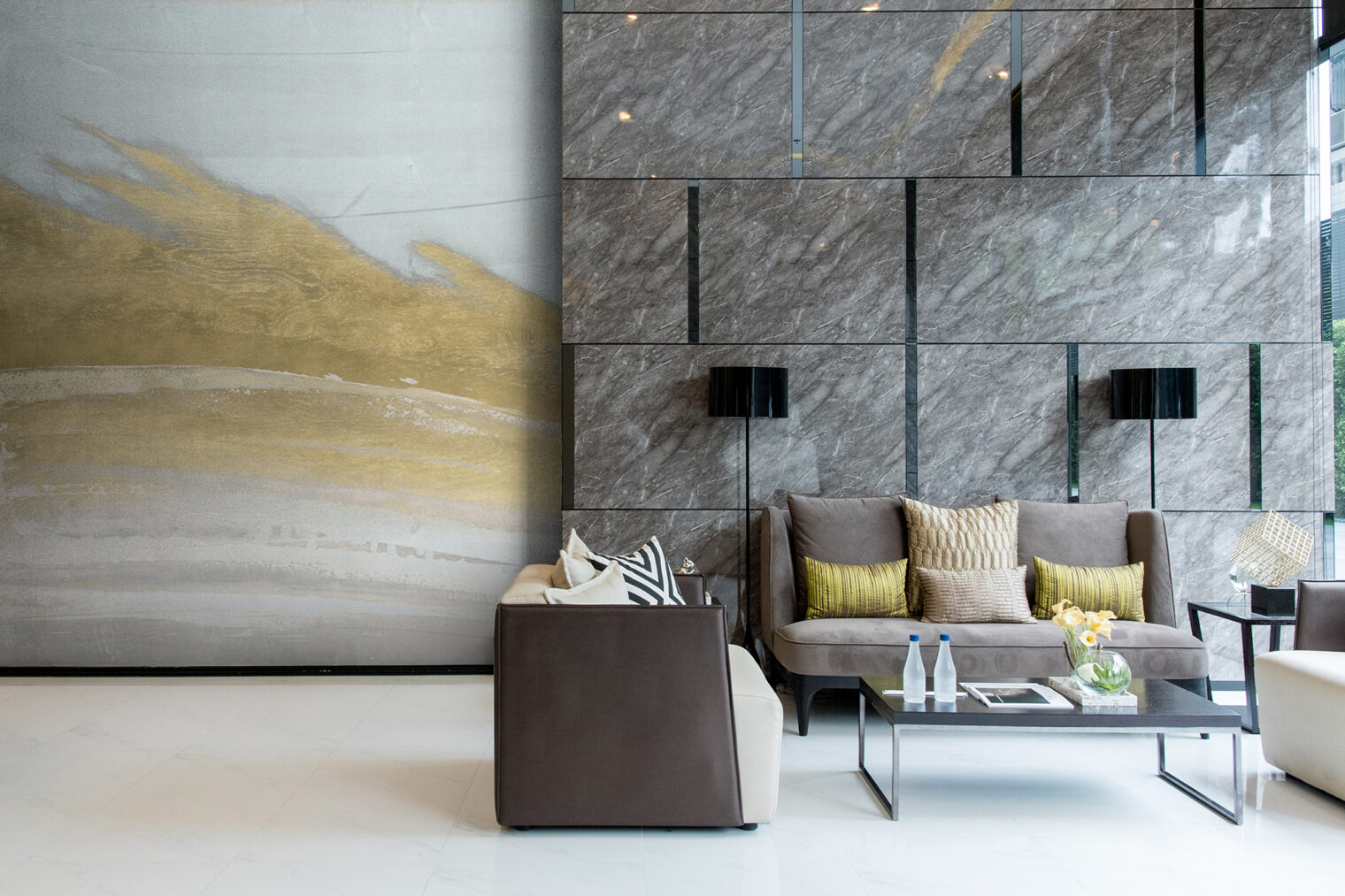 ホテルロビーの大理石調の壁装材に合わせたゴールドを主役にした壁紙が、空間をよりラグジュアリーな印象に引き立てる。