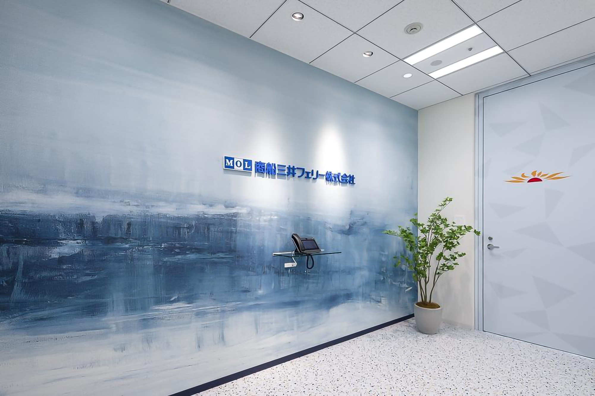 東京都千代田区のオフィスのエントランス部分にて壁紙と化粧用フィルムを採用。アーティスティックなブルーのデザインを展開