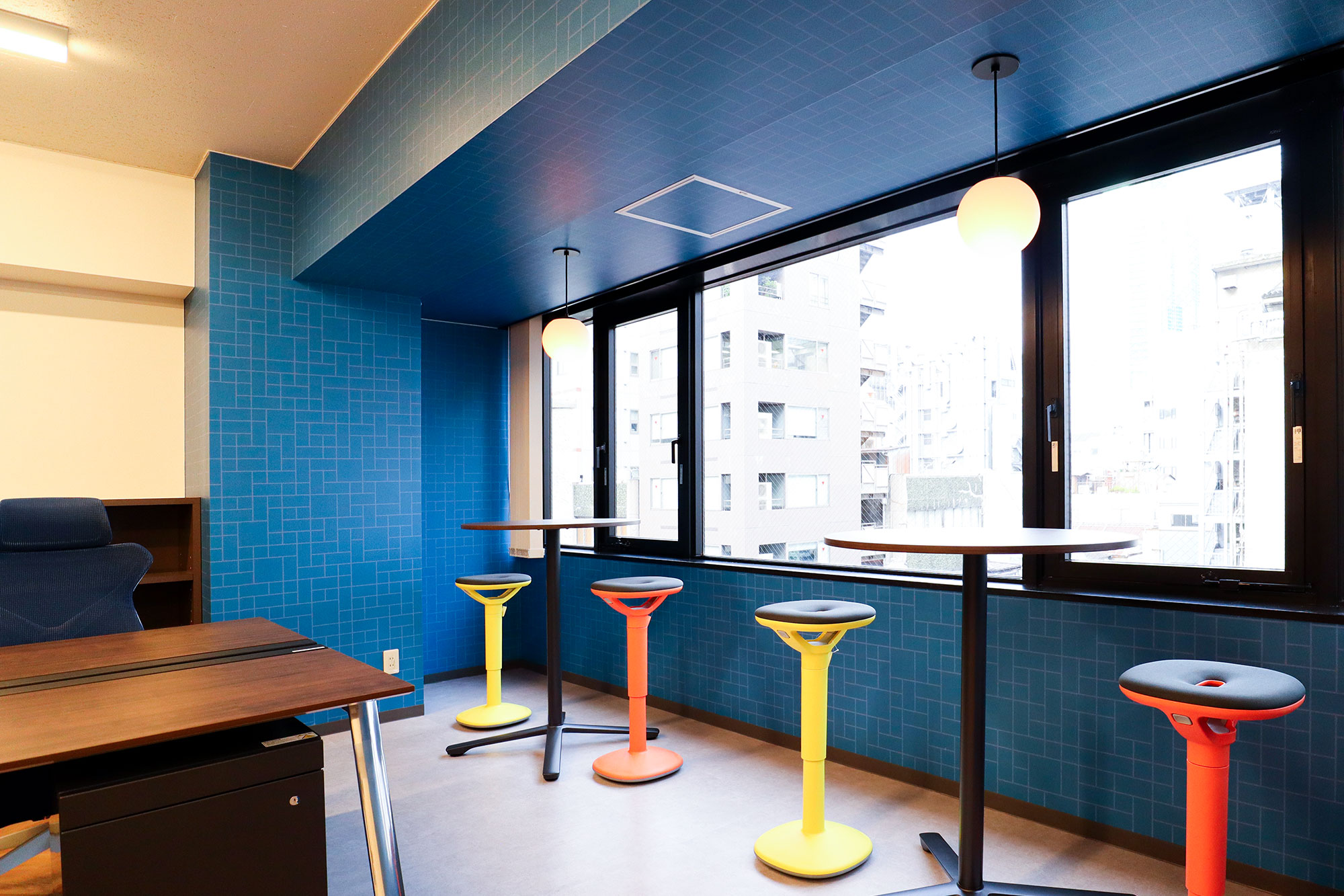 東京都港区のオフィス、窓際の一角の壁面へアクセントとして、ブルーが印象的な幾何学模様「CIRCUIT / P087A」を配した