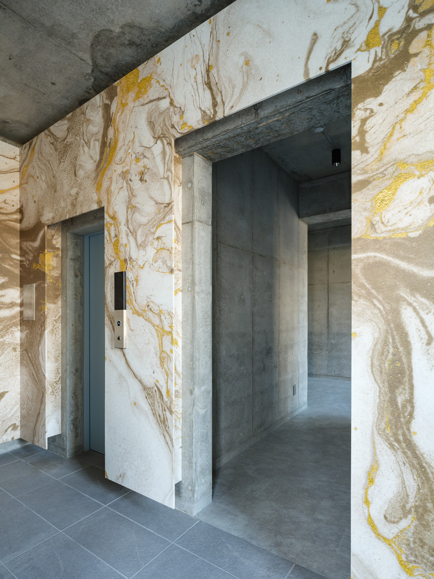 鹿児島県霧島市の集合住宅エントランスとエレベーターホール壁面へ、大理石を感じさせるようなマーブル調のlookシリーズの「Surreal / LKSR005」を展開