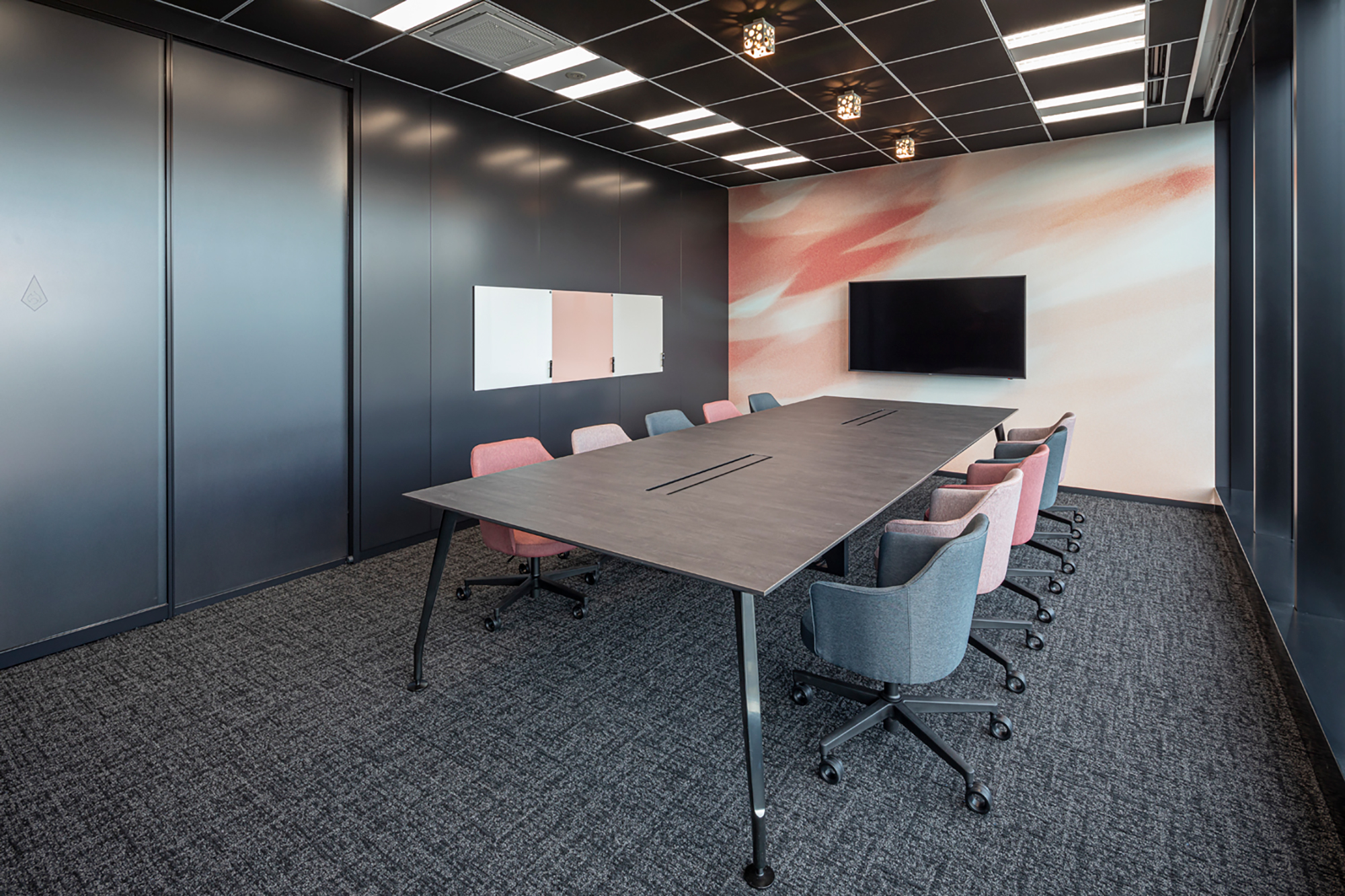 東京都千代田区のオフィス内会議室のアクセントクロスとしてピンクの揺れ動くテクスチャが特徴的なデザインを配置