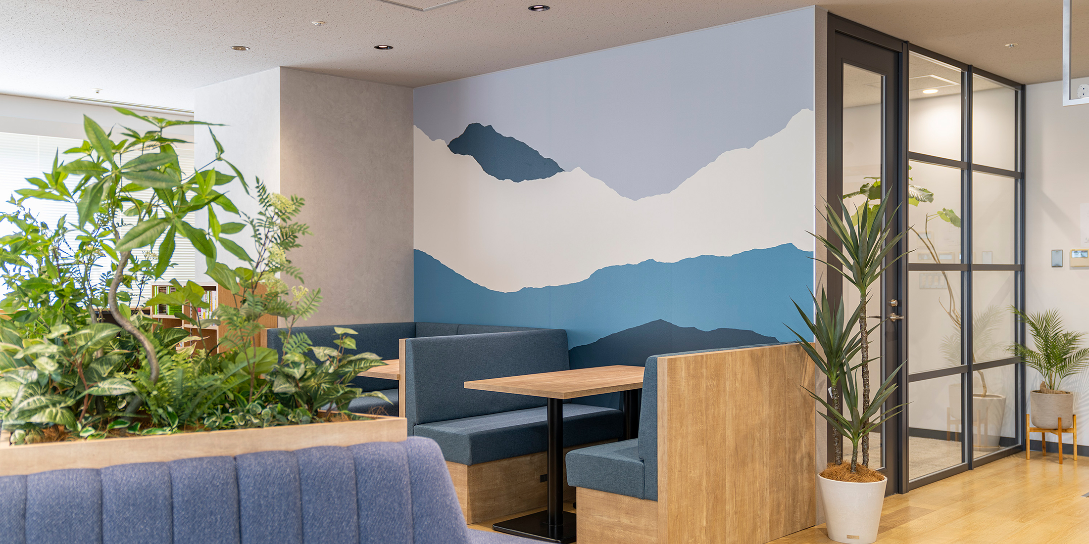 東京都渋谷区のオフィス・オープンスペースへコーポレートカラーであるブルーの山並みをグラフィカルに表現した壁紙を施工